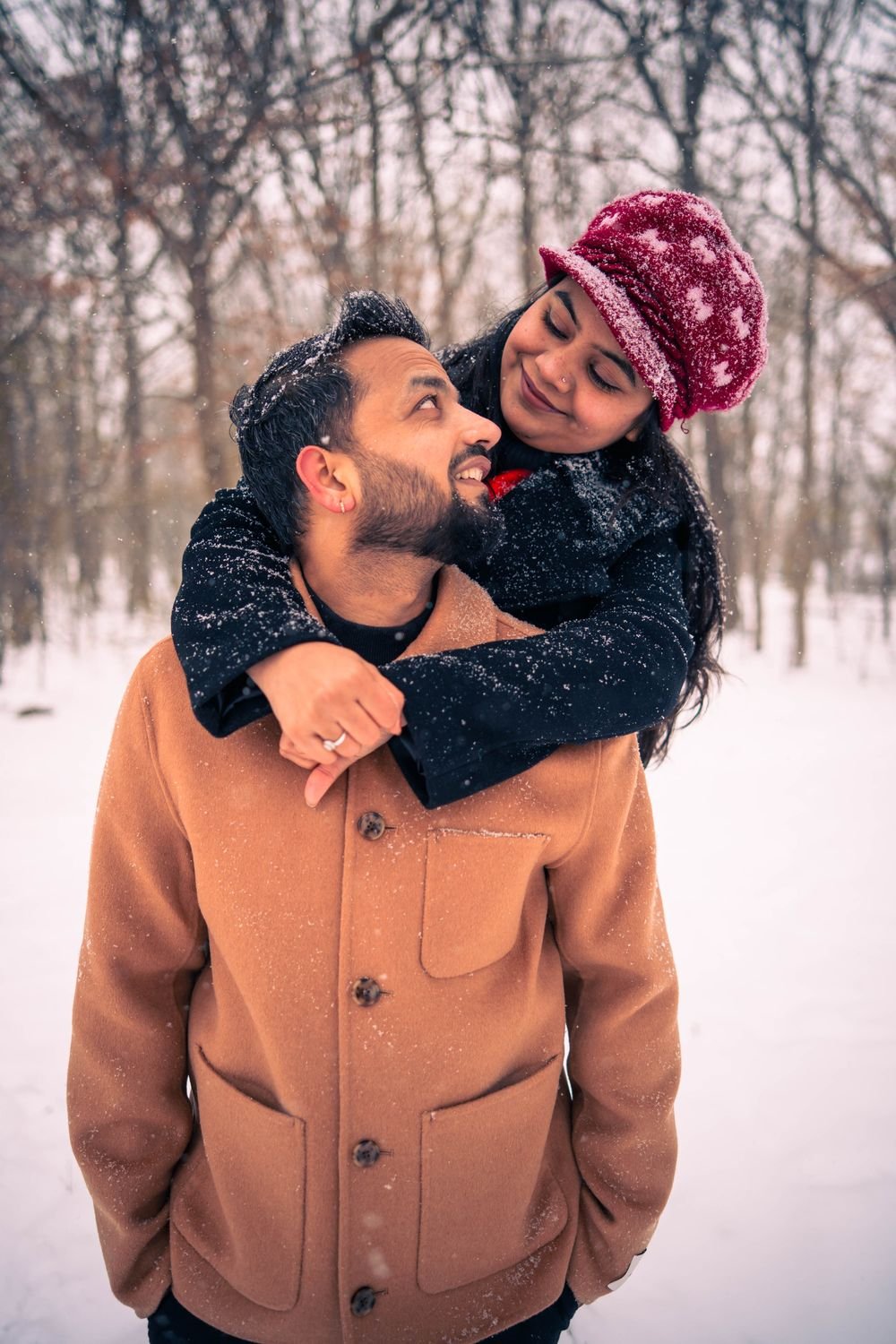 Couple among snowy pines during a winter session near Windsor